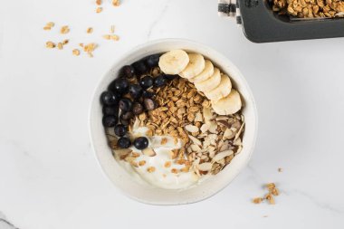 Yunan yoğurdu, badem, yabanmersini ve muzlu ev yapımı granola. Sağlıklı kahvaltı konsepti, tarif.