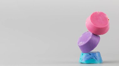 Doğal el yapımı sabun. Gri arkaplanda piramit şeklinde parlak sabun parçaları dengesi. Boşluğu kopyala