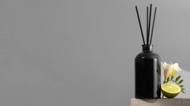 Çiçek ve limon kokulu siyah cam ayırıcı. Ev konforu, odanın parfümleri. Bambu çubuklu dağıtıcı. Uzayı kopyala Pankart