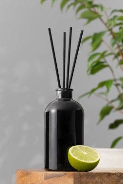 İçinde limon kokulu oda parfümü olan siyah bir şişedeki bambu çubukları. Ev için güzel kokulu cam ayırıcı. Aromaterapi.