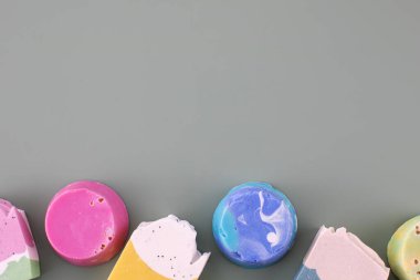 Yeşil arka planda farklı şekillerde ve el yapımı sabunların renkleri. Doğal kozmetik konsepti, hijyen. Boşluğu kopyala