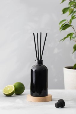 İçinde limon kokulu oda parfümü olan siyah bir şişedeki bambu çubukları. Ev için güzel kokulu cam ayırıcı. Aromaterapi.