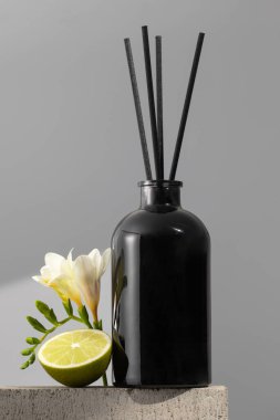 Çiçek ve limon kokulu siyah cam ayırıcı. Ev konforu, odanın parfümleri. Bambu çubuklu dağıtıcı.