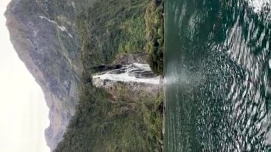 Yeni Zelanda 'da fiyort şelalesi. Milford Sound 'da. Seyahat et. Dikey video.