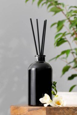 Çiçek kokulu siyah cam dağıtıcı. Ev konforu, odanın parfümleri. Bambu çubuklu dağıtıcı.