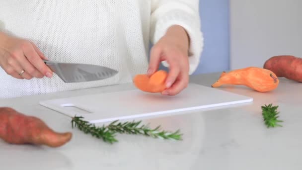 Eine Frau Schneidet Süßkartoffeln Auf Einem Schneidebrett Das Der Küche — Stockvideo