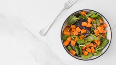 Tatlı patates ve susam tohumlu yeşil salata. Vejetaryen yemeği. Sağlıklı beslenme kavramı. Boşluğu kopyala