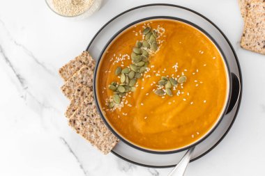 Kabak çorbası püresi, balkabağı ve susam tohumlu bir tabak. Sonbahar menüsü konsepti. Kolay vejetaryen tarifleri, ezilmiş çorba..