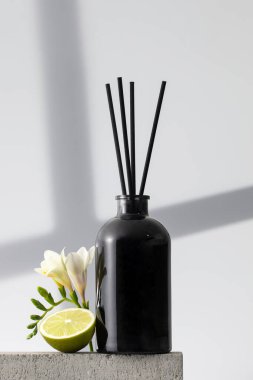 Çiçek ve limon kokulu siyah cam ayırıcı. Ev konforu, odanın parfümleri. Bambu çubuklu dağıtıcı.