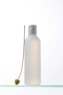 Cam bir rafta logonuz için bir şişe kozmetik. Rutin cilt ve saç bakımı için kozmetik ürünleri.