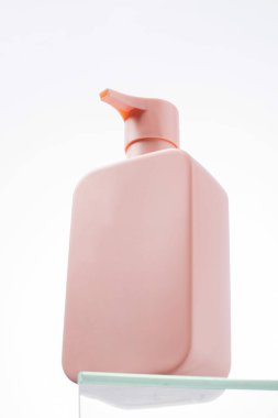 Cam rafta logosu olan bir kozmetik ürününün pembe maketi. Şampuan, duş jeli. Cilt bakımı.