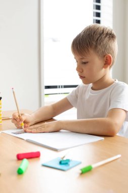 Sevimli bir çocuk cetvel ve kalemle çizim yapıyor. Ev dersleri konsepti, uzaklardan öğrenme. Geometri ve çizim.