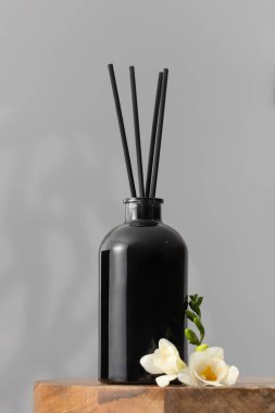 Çiçek kokulu siyah cam dağıtıcı. Ev konforu, odanın parfümleri. Bambu çubuklu dağıtıcı.