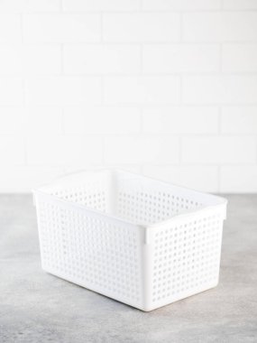 Beyaz plastik depolama sepeti. Evde depo düzenleme konsepti.