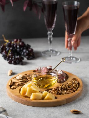  Ahşap bir hayvanat bahçesinde şarap için atıştırmalıklar. Peynir, sosis, ahşap tabakta böğürtlen, atıştırmalık şenlikli servis..