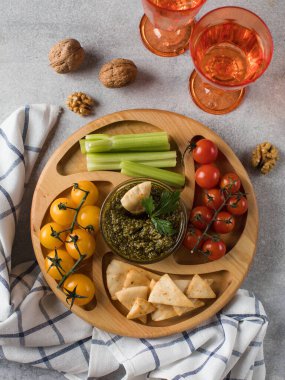 Tahta bir tabakta taze sebzelerin karışımı. Vejetaryen atıştırması. Biber parçaları, menazitsa soslu kereviz. Vejetaryenlik.