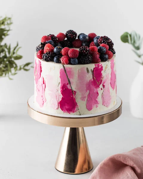 Delicious cake with cream and fresh berries on the cake pan. The concept of a birthday cake, a wedding. Birthday cake.