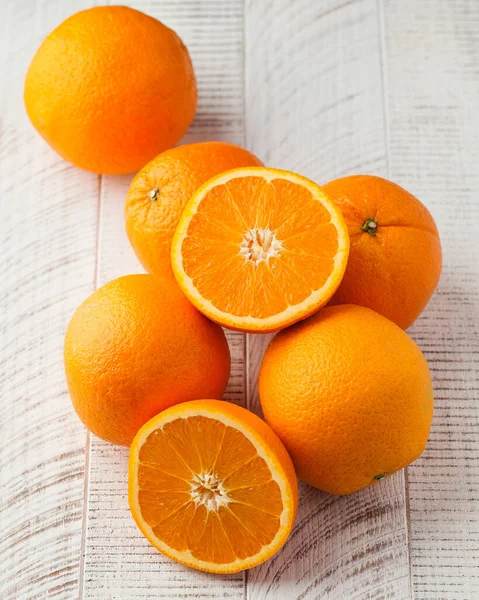 A group of ripe oranges on a white wooden background. Citrus fruits. Fruit concept.