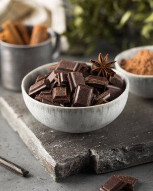 Gri arkaplanda siyah zanaatkar çikolatası küpleri. Organik acı çikolata..