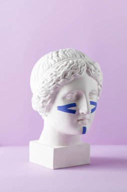 Mor arka plandaki büstteki yüz için mavi kasetler. Cerrahi olmayan yüz gerdirme, gençleştirme kavramı..