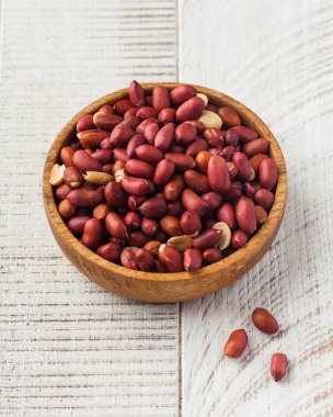 Kabukta kavrulmuş fıstık, ahşap bir arka planda ahşap bir kasede. Fındık kavramı.