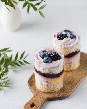 Lezzetli bir tatlı, bir bardak kek ve taze böğürtlen. Porsiyonlu tatlı, fırın konsepti, kafe.