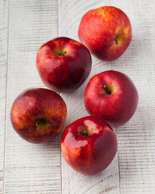 Tahta beyaz arka planda olgun, sulu kırmızı elmalar. Hasat konsepti.