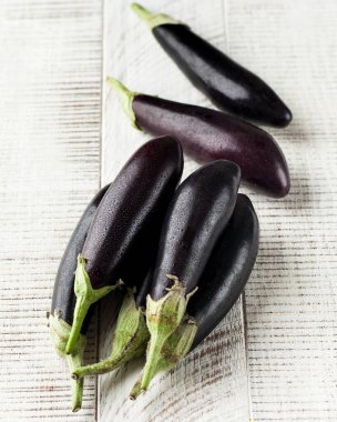 Beyaz ahşap arka planda taze, olgun patlıcanlar. Sağlıklı yiyecek, sebze kavramı..