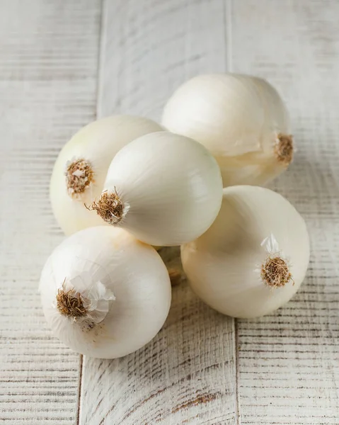 White onion on a white wooden background. The concept of healthy food, vegetables.