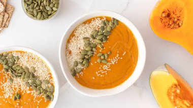 Kabak çorbası püresi, balkabağı ve susam tohumlu tabaklar. Sonbahar menüsü konsepti. Kolay vejetaryen tarifleri, ezilmiş çorba..