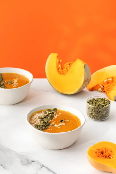 Plates with pumpkin soup puree, pumpkin and sesame seeds. The concept of the autumn menu. Easy vegetarian recipes, mashed soup.