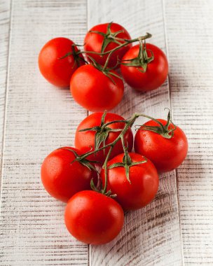 Beyaz ahşap arka planda olgun sulu domatesler. Sağlıklı yiyecek, sebze kavramı..