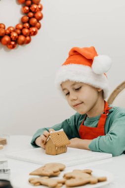 Noel arifesinde tatlı bir çocuk Noel Baba şapkasıyla mutfakta zencefilli ev yapar. Mutlu yıllar ve Noel. Kendi ellerinle bir hediye..