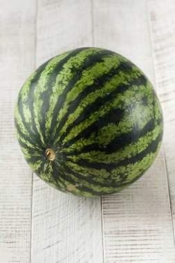 Hafif ahşap zemin üzerinde sulu olgun karpuz. Hasat, meyve, meyve pazarı kavramı..