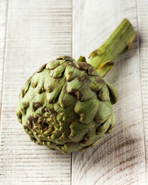 Hafif ahşap zemin üzerinde olgun çiğ enginar. Sağlıklı beslenme kavramı