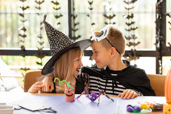 Şirin erkek ve kız kardeşler, Cadılar Bayramı 'nı kutlamak için karnaval kostümleriyle eğlenir ve el işi yaparlar. Mutlu Cadılar Bayramı. 