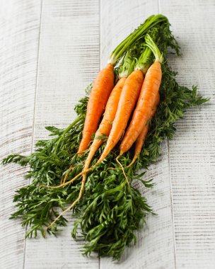 Beyaz ahşap arka planda bir yığın havuç. Sebze konsepti, hasat....