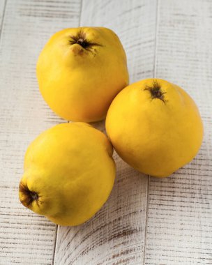 Beyaz ahşap bir arka planda sulu olgun ayva meyveleri. Sağlıklı yemek, meyve, hasat kavramı.