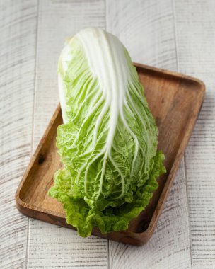 Beyaz ahşap arka planda taze Çin lahanası. Sağlıklı beslenme, sebze, hasat...