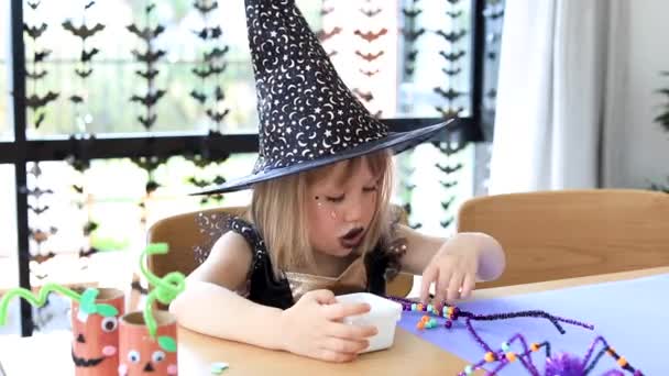 Egy Cuki Lány Boszorkányjelmezben Vicces Pókot Csinál Halloweenkor Saját Kezével — Stock videók
