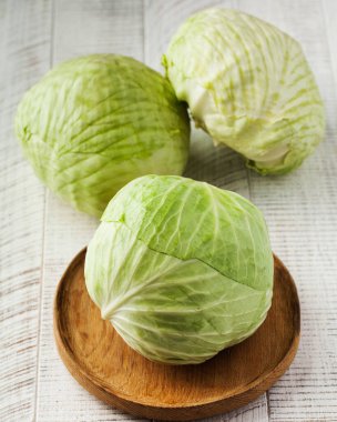 Beyaz ahşap arka planda olgun beyaz lahana. Sebze konsepti, hasat....