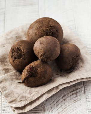 Beyaz ahşap arka planda yıkanmamış kirli pancar kökü. Sebze konsepti, hasat....