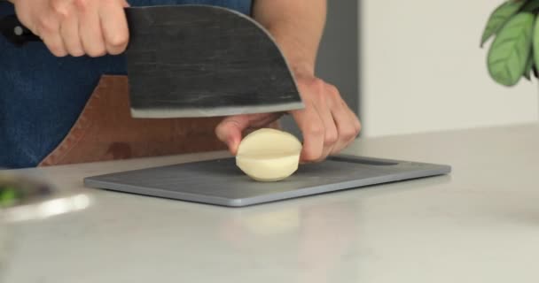 厨师在厨房的木板上用菜刀切生皮土豆 4K视频 录像配方 — 图库视频影像