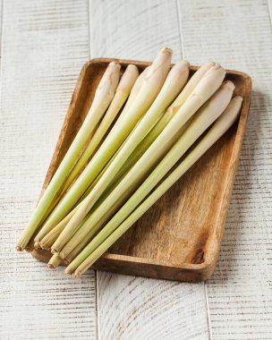 Tahta bir tabakta beyaz ahşap bir arka planda taze limon otu.. 