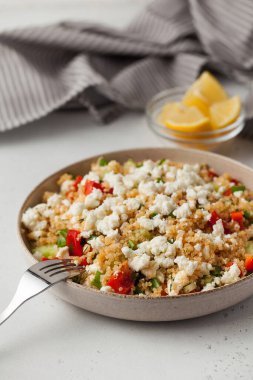 Peynirli kinoa salatası ve tabakta taze sebze. Vejetaryen tarifleri kavramı.