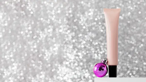 A tube with skin care products on the podium with Christmas balls on a bright silver background. The concept of New Years gifts, protective skin care products in winter. Copy space