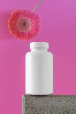 Mockup, içinde haplar ya da vitaminler olan beyaz bir kavanozdur. Tıbbi hazırlık kavramı, kadınlar için vitaminler