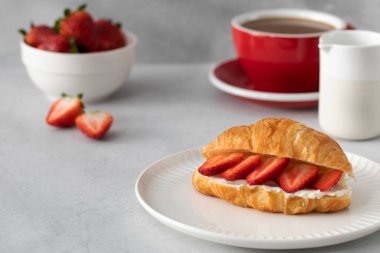 Taze ricotta ve taze çilekli kruvasan. Fransız kahvaltısı konsepti. Sade kahveyle kruvasan..