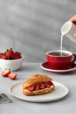 Taze ricotta ve taze çilekli kruvasan. Fransız kahvaltısı konsepti. Sade kahveyle kruvasan..