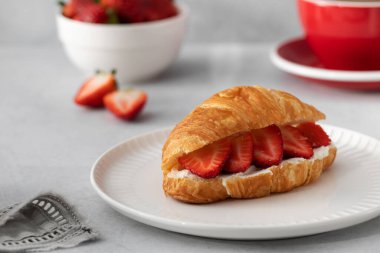 Taze ricotta ve taze çilekli kruvasan. Fransız kahvaltısı konsepti. Sade kahveyle kruvasan..